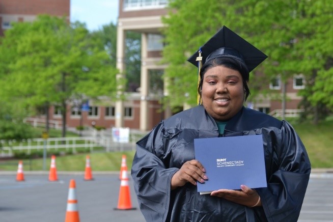 Bovanna Phillips in her graduation cap and gown, holding her degree.