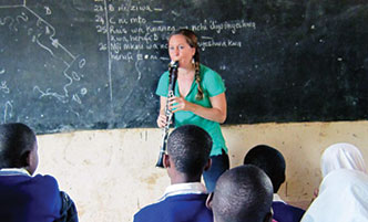 Michele Von Haugg playing her clarinet in front of a classroom full of students. 