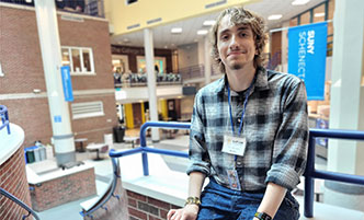 Nico Conchetti sitting on the stairs above the Elston Hall student commons.