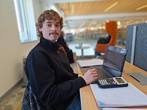 Student in Begley Learning Commons, working on a laptop.