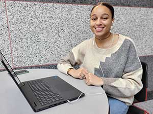 Student working at a laptop in the Commons.