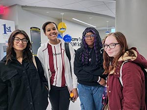 Four students standing together in the commons. 