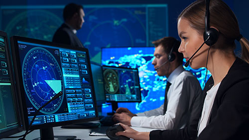 Air Traffic Controllers working in a tech-heavy setting