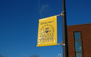 Lamp post with a SUNY SCCC welcome sign hanging from it.