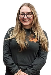 Female student with long blonde hair, glasses, wearing a black shirt. 