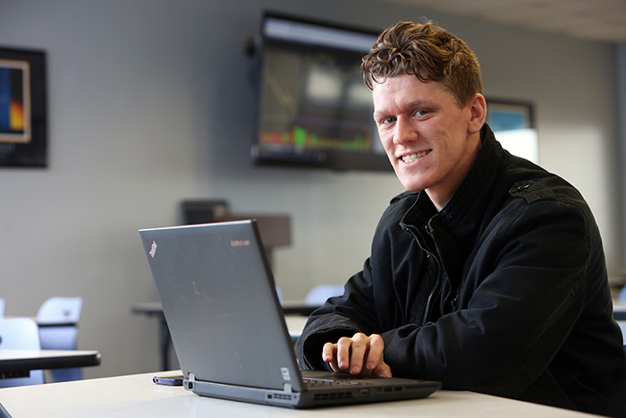 Male student sitting at a laptop.