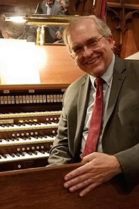 Headshot of Al Fedak, sitting in front of an organ.