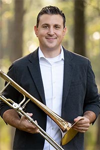 Phil Pandori holding a trombone.