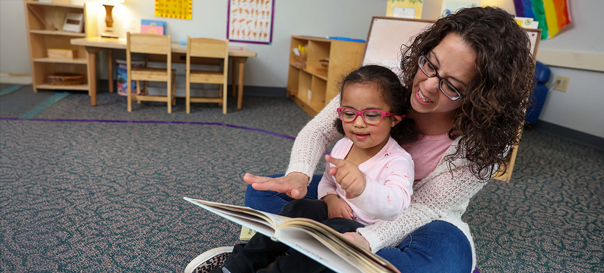 An early childhood student works with a preschooled-aged student in the on-campus preschool. 